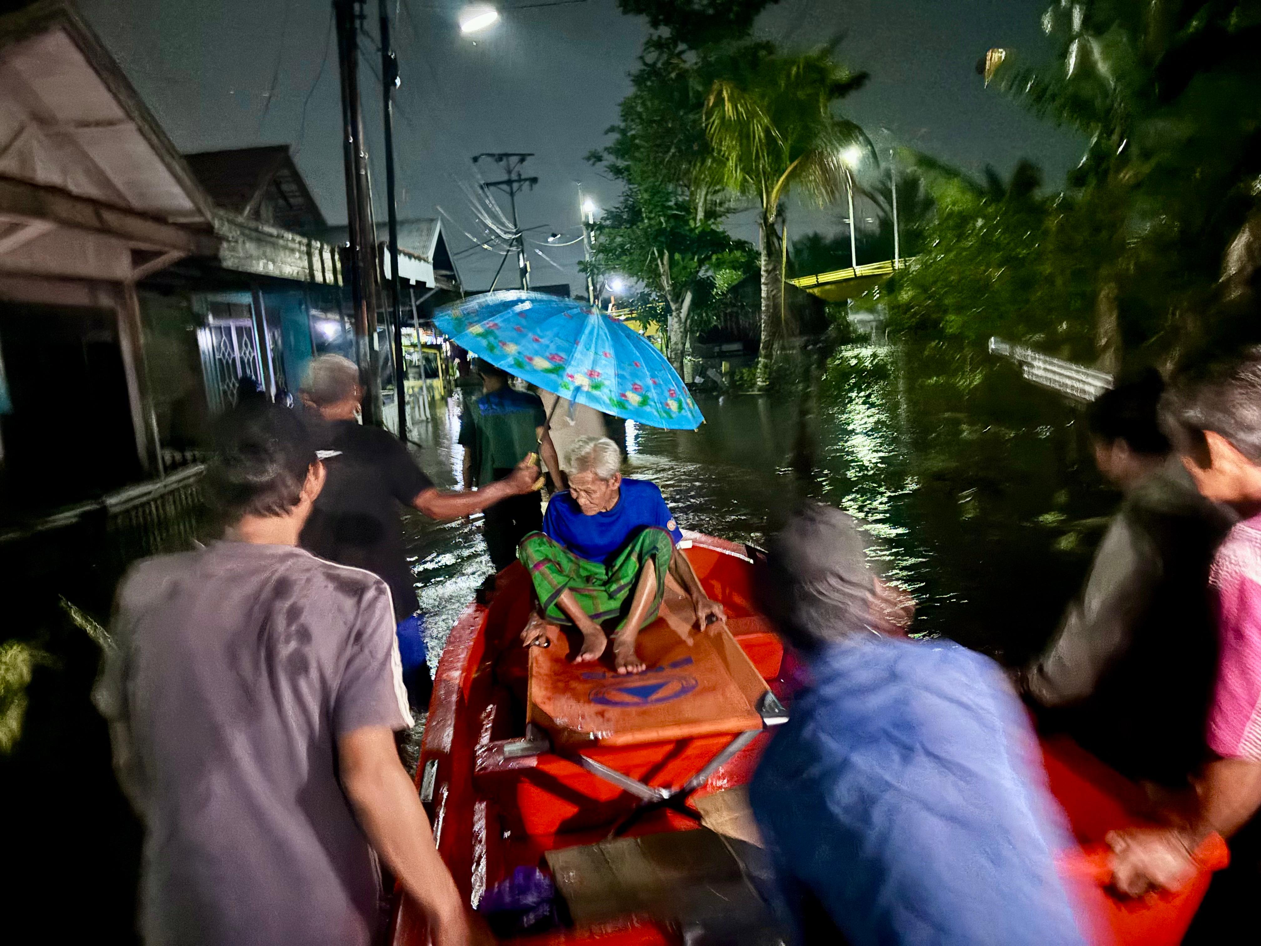 LANSIA Pengungsi banjir di Sungai Lulut, Suriansyah, dievakuasi menggunakan perahu menuju ambulans, tadi malam.