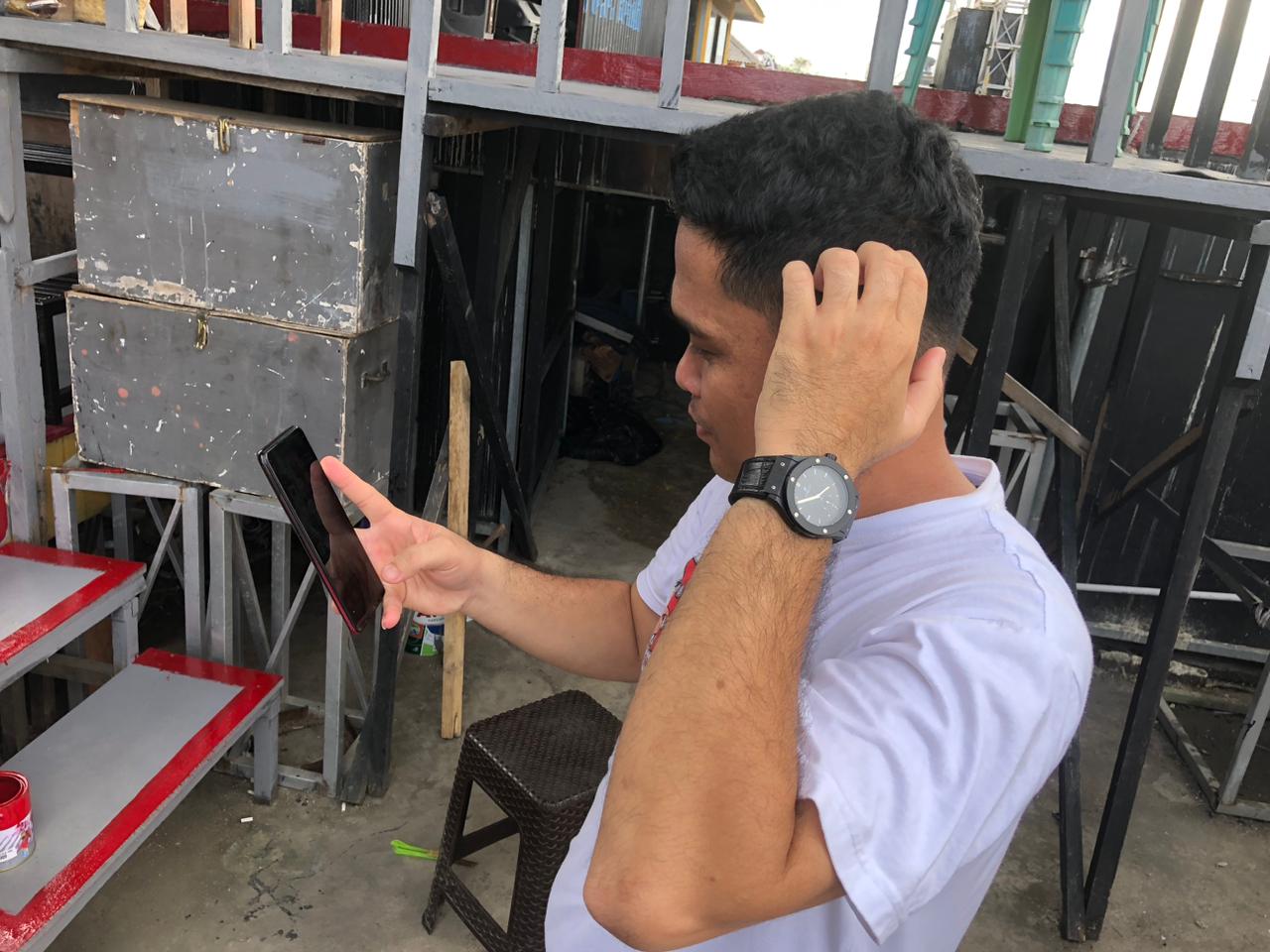 KESAL: Salah satu warga Kotabaru yang mengeluh jaringan internet di handphonenya. Penyebabnya kabel laut jaringan Telkomsel ternyata putus lagi.