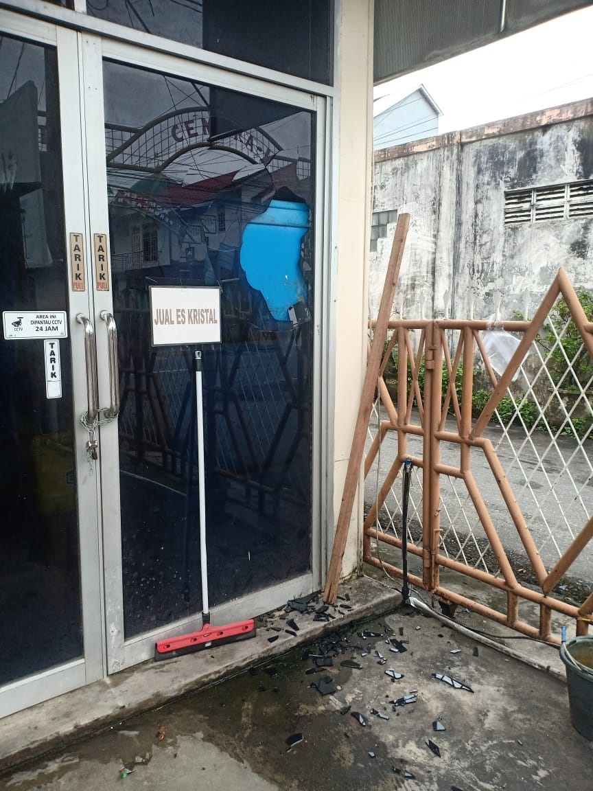 PECAH: Pintu kaca kios penjual teh di Jalan Cemara Raya, Sungai Miai, pecah akibat ulah kelompok remaja bersajam, Minggu (11/1/2026) subuh.&nbsp;