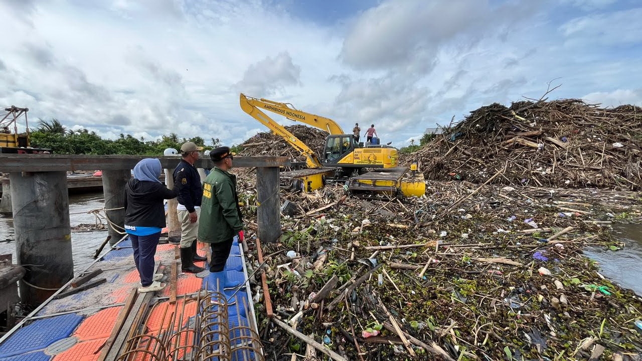 DICEGAH HANYUT: Tumpukan batang pohon dan kayu kiriman dari hulu Sungai Martapura tersangkut di perangkap sampah apung kawasan Sungai Gampa, Banjarmasin.
