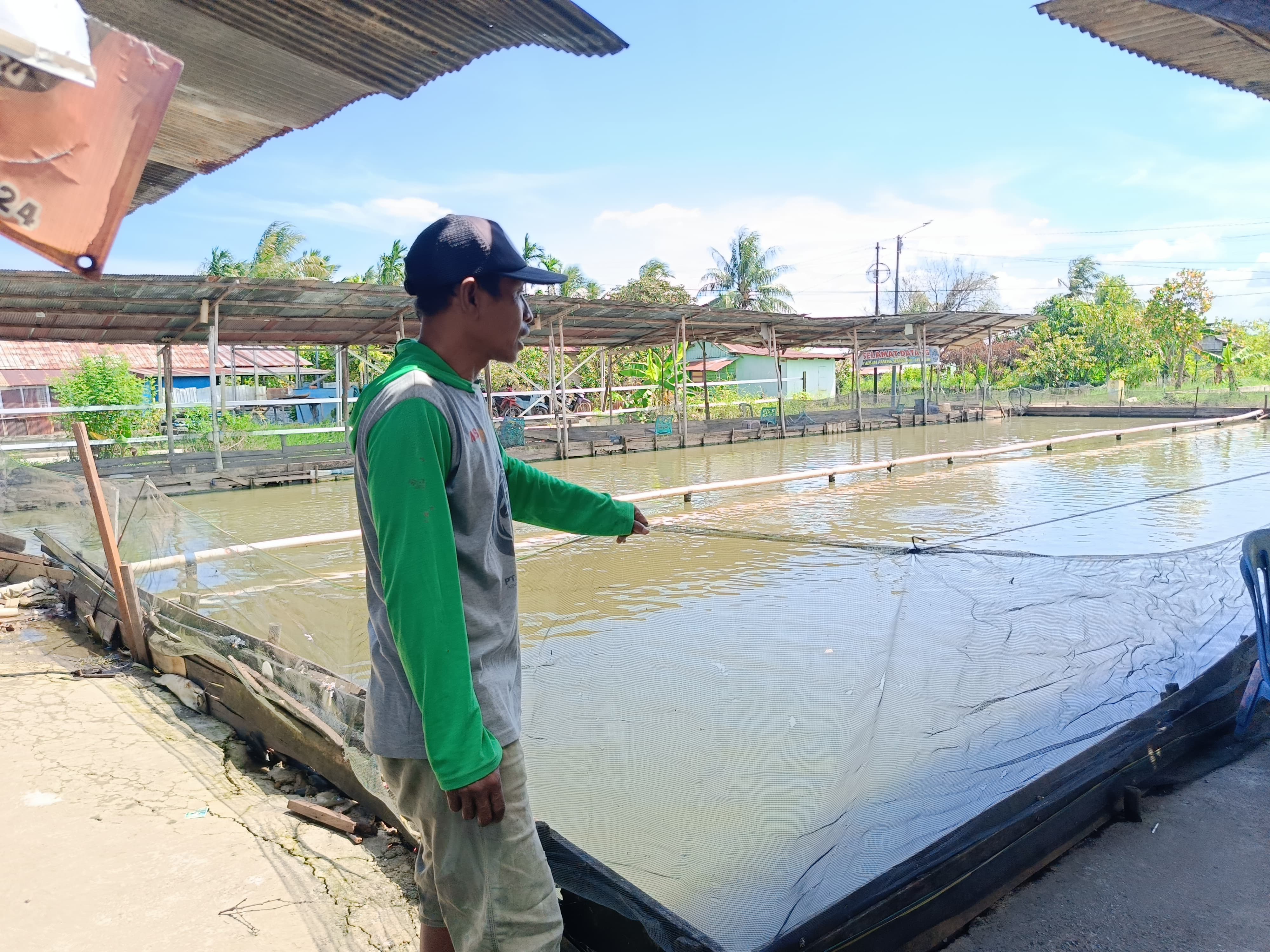 MENUNJUKKAN: Pemilik saat menunjukkan kondisi kolam miliknya yang sebelumnya terendam banjir.