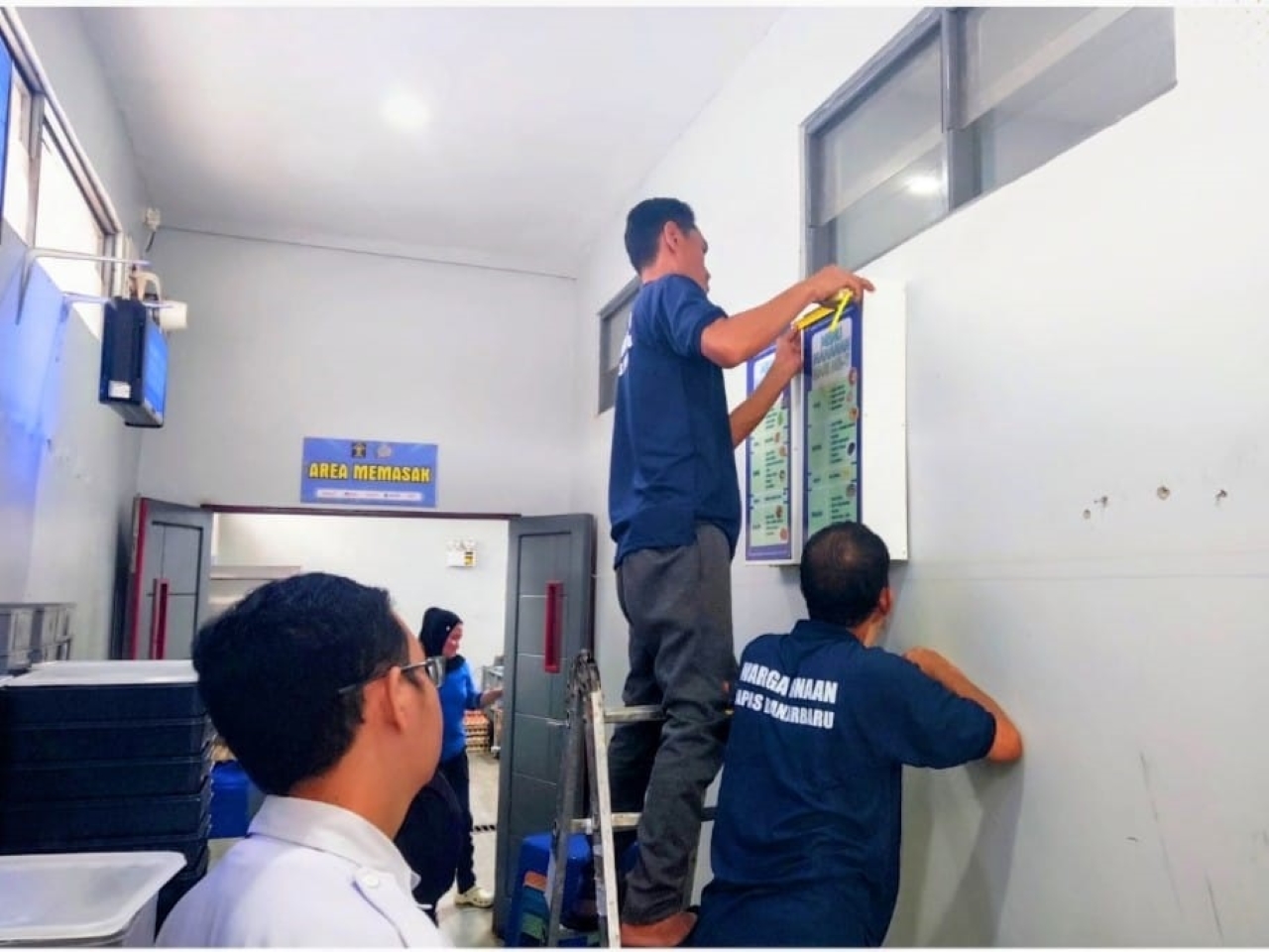 MEMASANG: Kristianto dan Suryadi, dua warga binaan Lapas Kelas IIB Banjarbaru saat memasang neon box di Lapas Perempuan Martapura, Kamis (15/1).