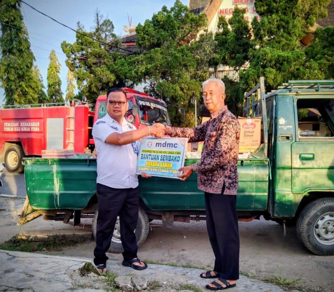 PEDULI:Bendahara PD Muhammadiyah HSU, H Khairin Noor serahkan paket bantuan banjir melalui BPBD HSU dan diterima Sekretaris BPBD HSU, Andry Rahmadillah.