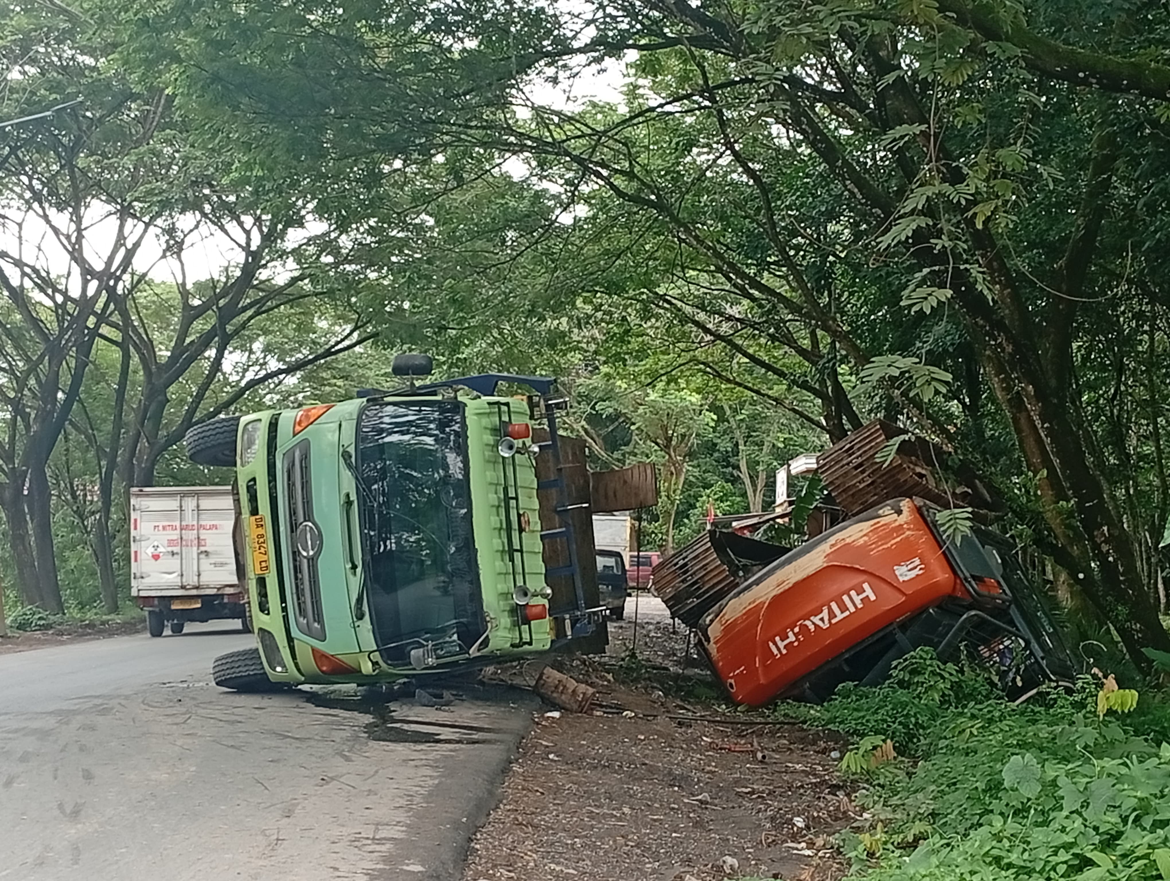 TERBALIK: Truk pengangkut alat berat terbalik di Jalan Bypass Jambu Hilir, Kandangan.