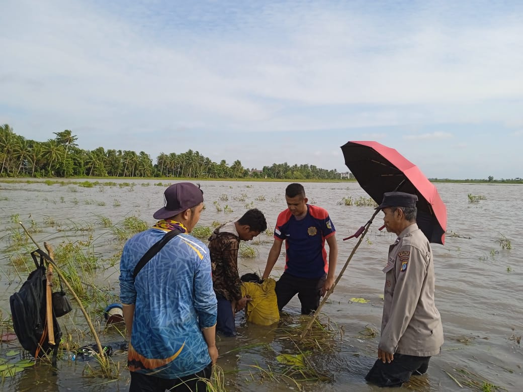 EVAKUASI: Personil Polsek Kurau saat melakukan pengamanan di lokasi penemuan mayat di areal persawahan di Desa Padang Luas, Kecamatan Kurau, Minggu (18/1/2026).