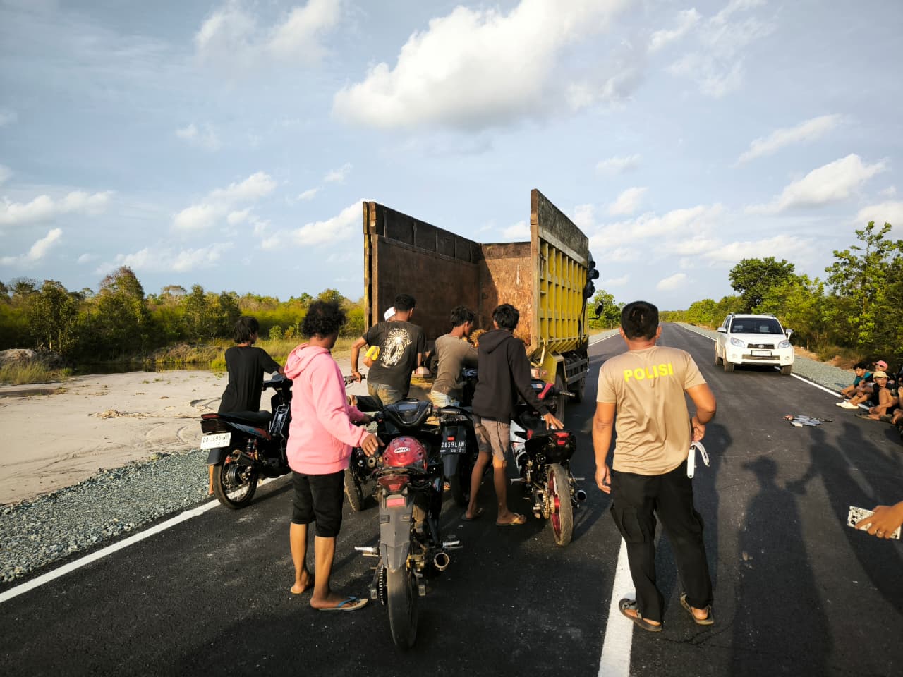 DIANGKUT: Personel Polsek Jorong saat mengangkut 27 kendaraan roda dua yang terlibat balapan liar di Jalan Pelabuhan Jorong, Minggu (18/1/2026).