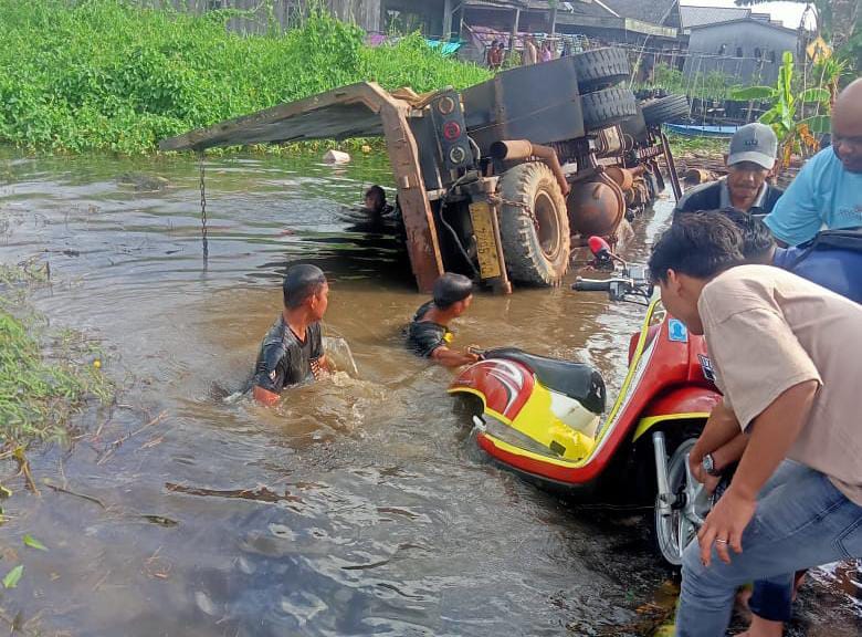 EVAKUASI: Warga saat mengevakuasi motor yang terendam karena truk pengangkutnya terbalik. (Grup Emergency)