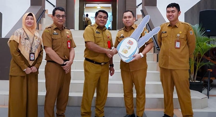 SIMBOLIS:Asisten Administrasi Umum Setda Banjarbaru, Kanafi (tengah) menyerahkan BMD kepada perwakilan UPPD Samsat Banjarbaru sebagai dukungan peningkatan pelayanan publik.