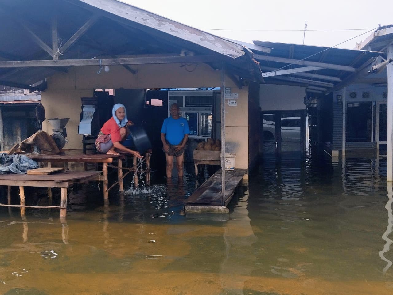 BERANGSUR SURUT: Warga melintasi genangan banjir yang mulai surut di Kecamatan Martapura, Kabupaten Banjar, Minggu (18/1).