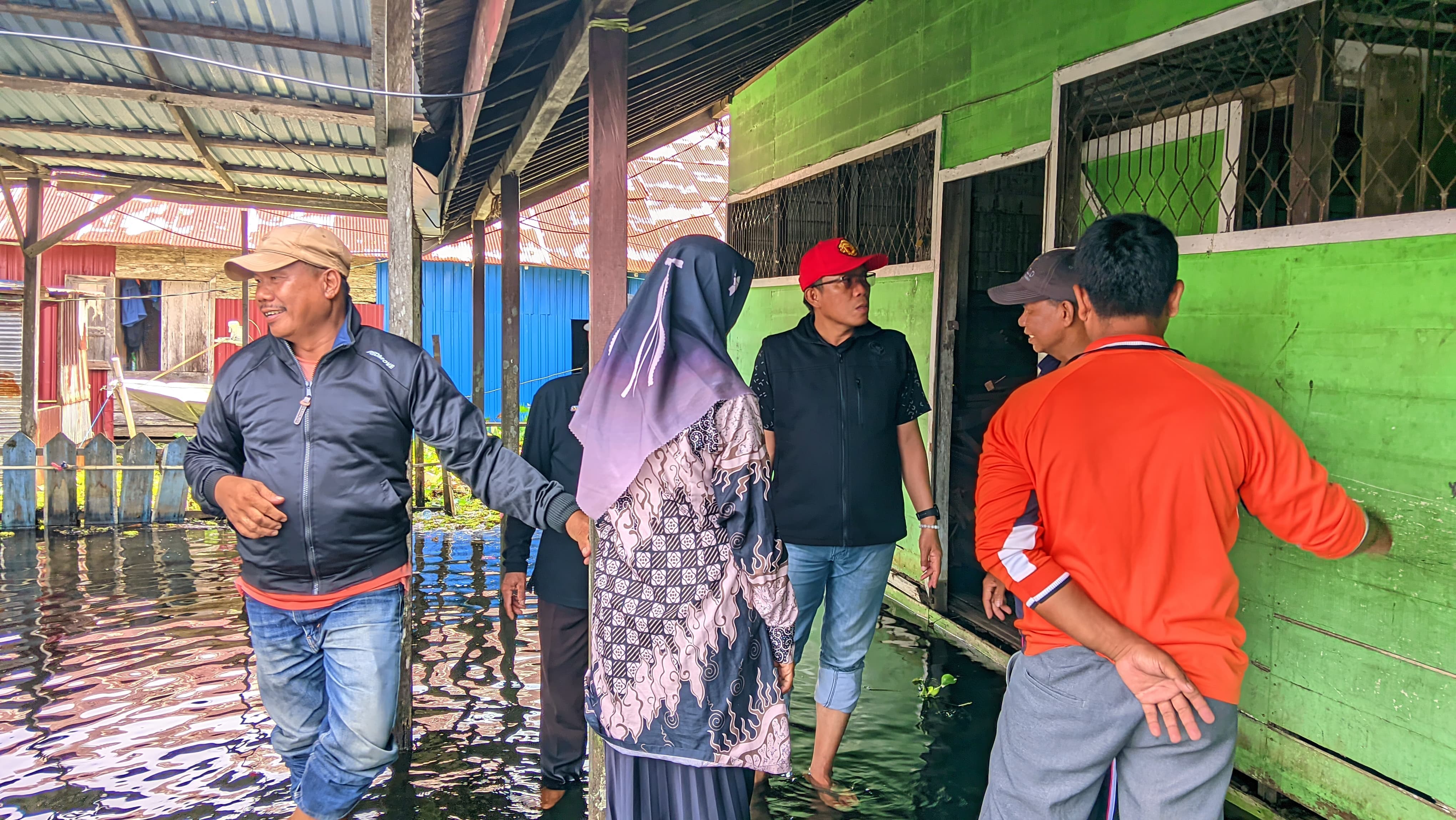 PEDULI: Anggota DPRD HSU Dr Tedy Suryana, yang juga anggota DPRD HSU meninjau dan menyerahkan bantuan banjir di Desa Pondok Babaris, Kecamatan Sungai Pandan, Rabu (21/1). (Foto: M.Akbar/Radar Banjarma