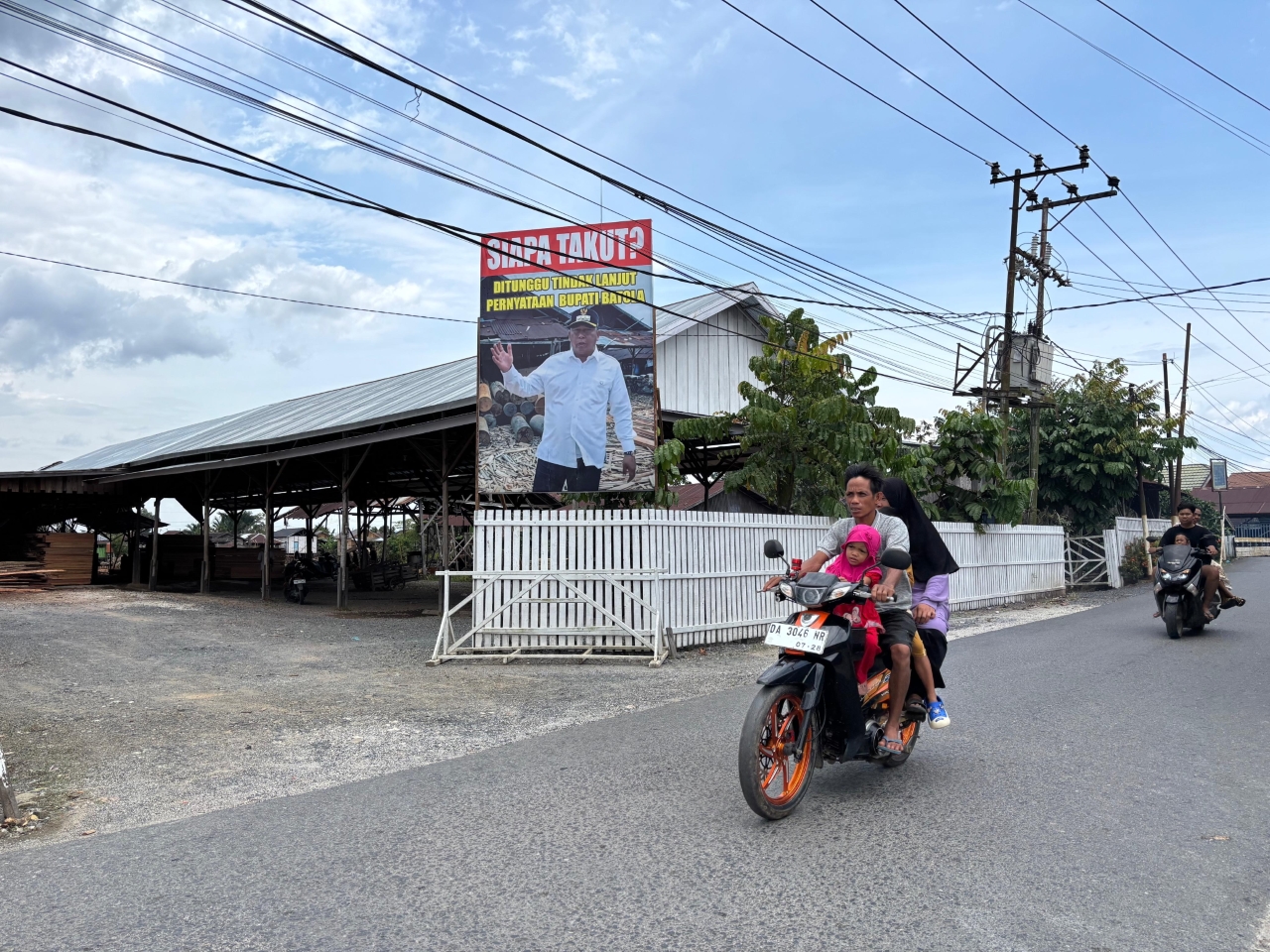 POLEMIK: Spanduk dengan foto Bupati Batola Bahrul Ilmi terpasang di Kelurahan Alalak Tengah, buntut video yang menyebut banjir di Batola berakar dari aktivitas galangan kayu.