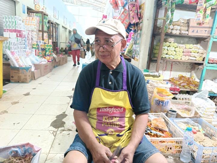 BERJUALAN: Suprapto saat berjualan bawang di Pasar Bauntung Banjarbaru, Senin (19/1).