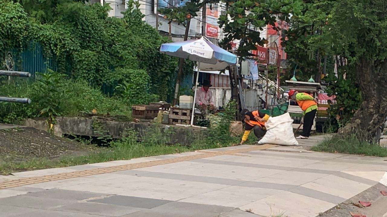 Saidah (58) bersama putrinya memunguti sampah yang menutupi trotoar di kawasan Jalan Ahmad Yani, Banjarmasin.