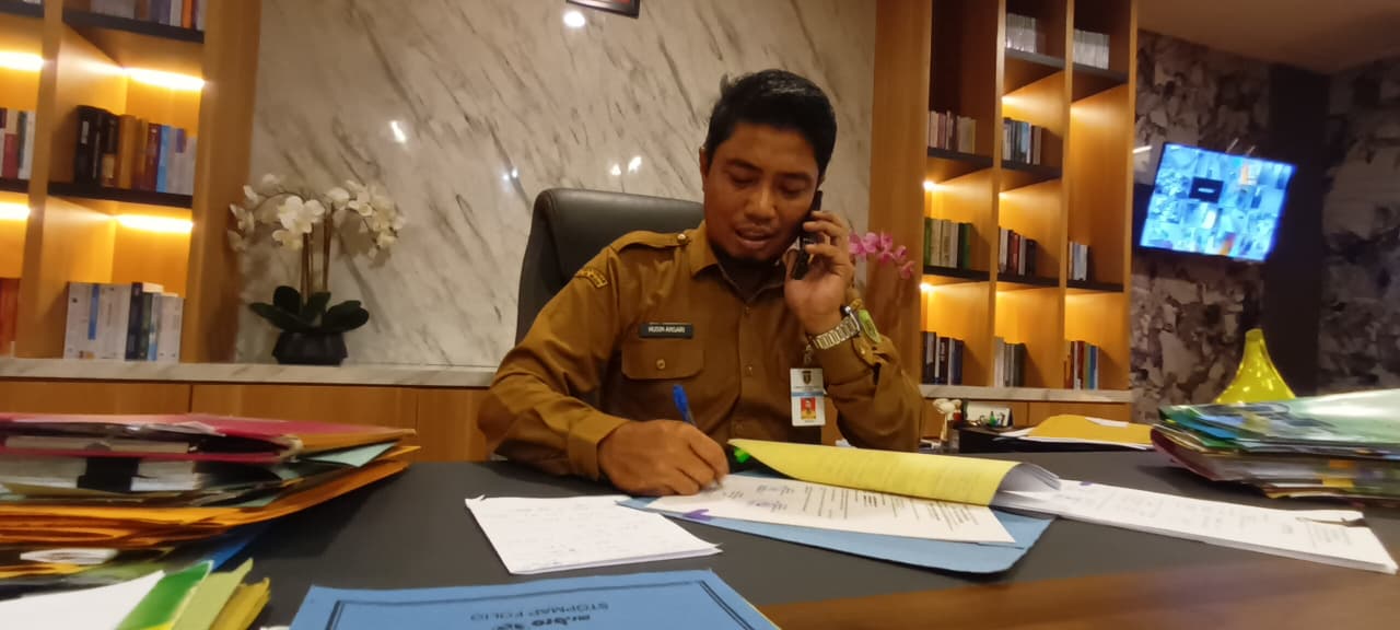 TANDA TANGAN: Kepala BPKAD Tabalong sekaligus Plt Kadinkes Tabalong, Husin Ansari di ruang kerjanya.
