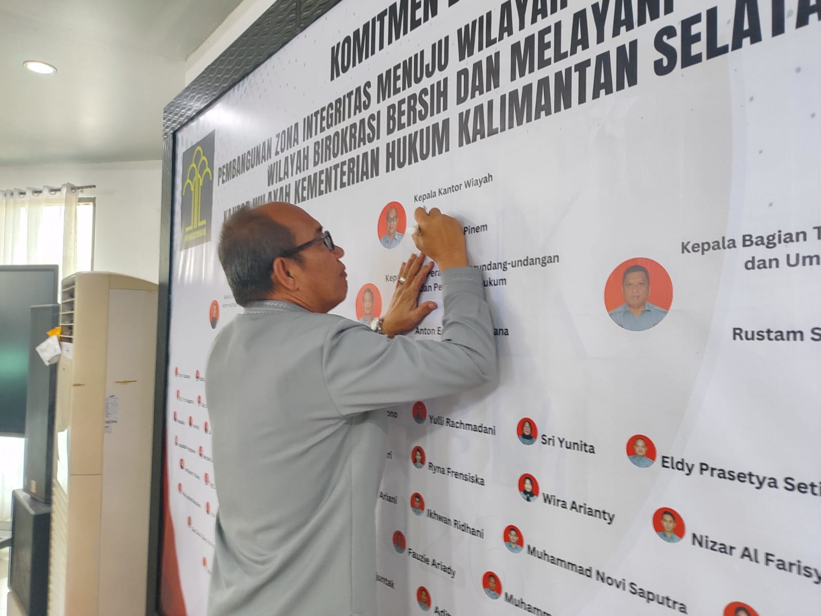 TELADAN:Kepala Kanwil Kemenkum Kalsel, Alex Cosmas Pinem menandatangani banner komitmen pembangunan Zona Integritas dan diikuti dengan jajaran pegawai lainnya.