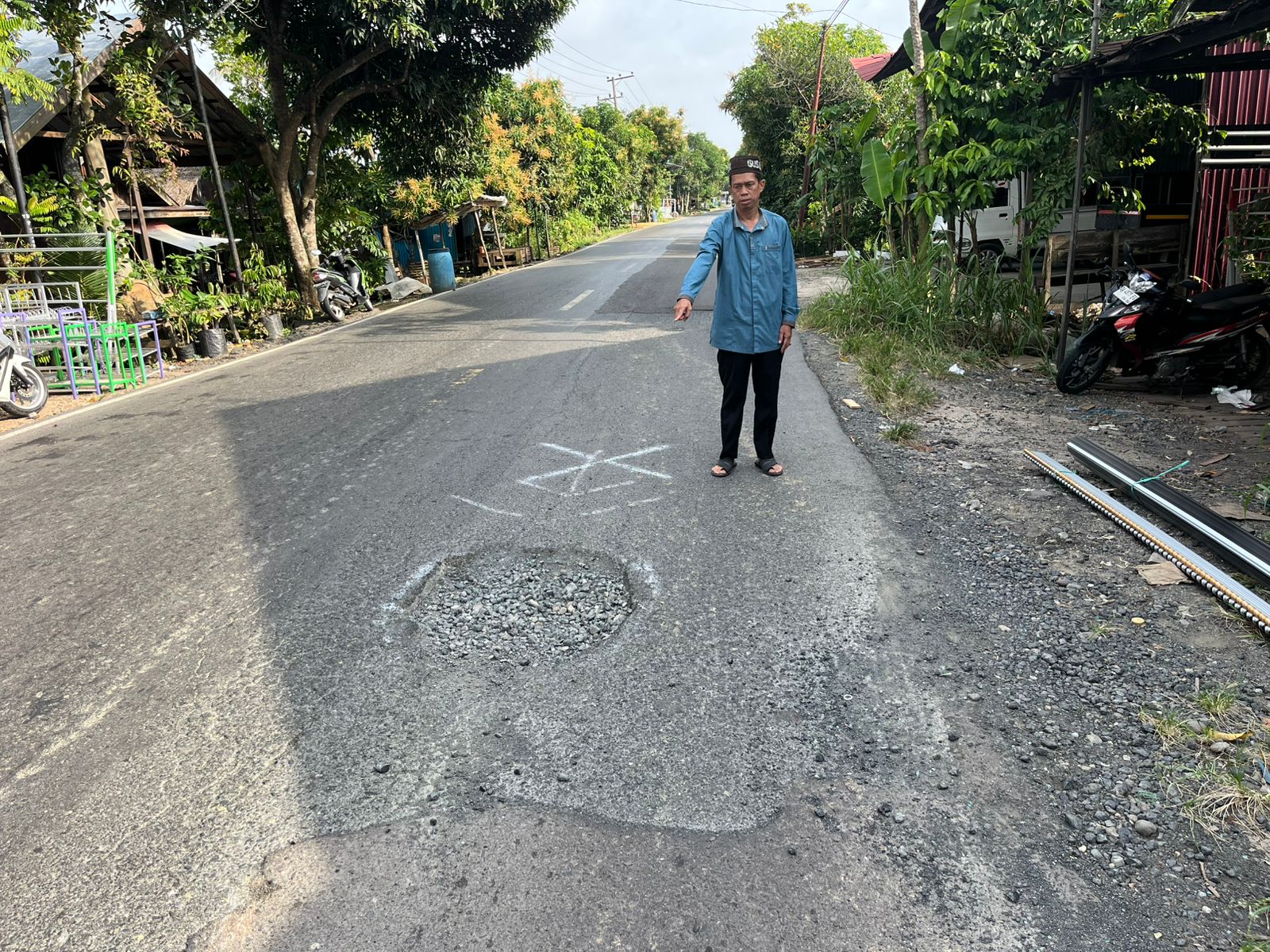 JALAN: Anggota DPRD HSU dari Fraksi PPP Abdurrahman, menunjukkan lubang jalan menyebabkan pengendara sepeda motor meninggal akibat terjatuh dan dihantam taksi colt dari arah belakang. (Foto: M.Akbar/R