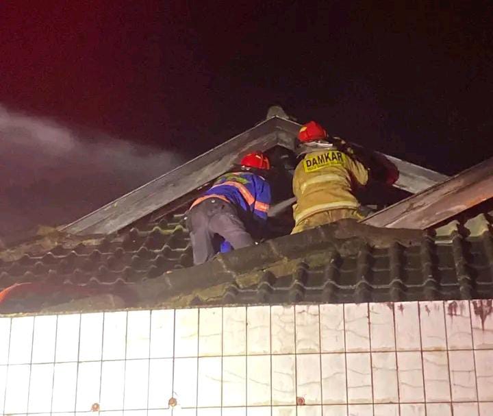 PLAFON: Petugas saat melakukan pemadaman di plafon atap rumah. (Foto: DAMKAR HSS)
