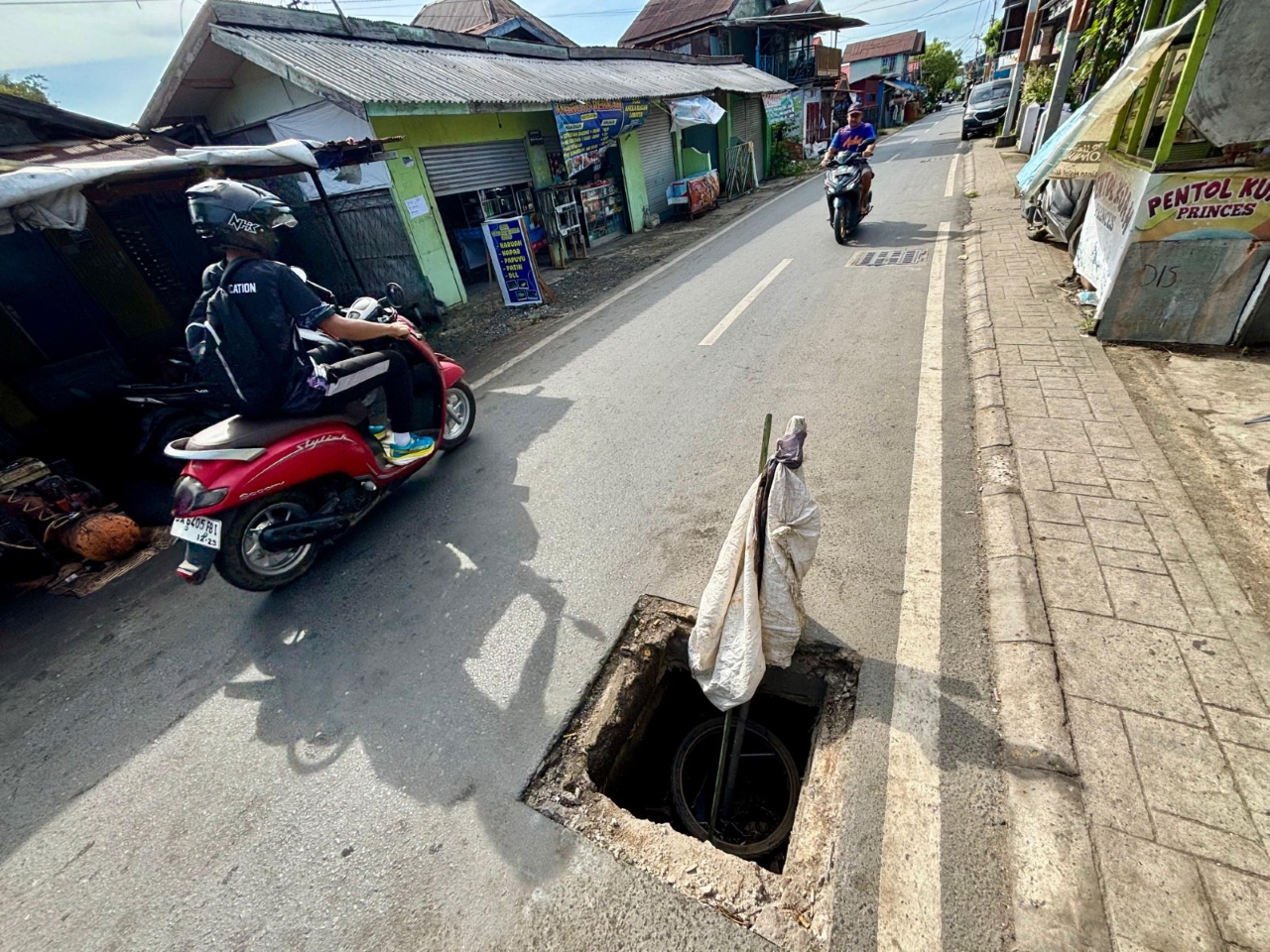 ANCAM KESELAMATAN: Jalan Kuin Selatan di Banjarmasin Barat berlubang akibat tutup drainase yang hilang diduga dicuri maling.