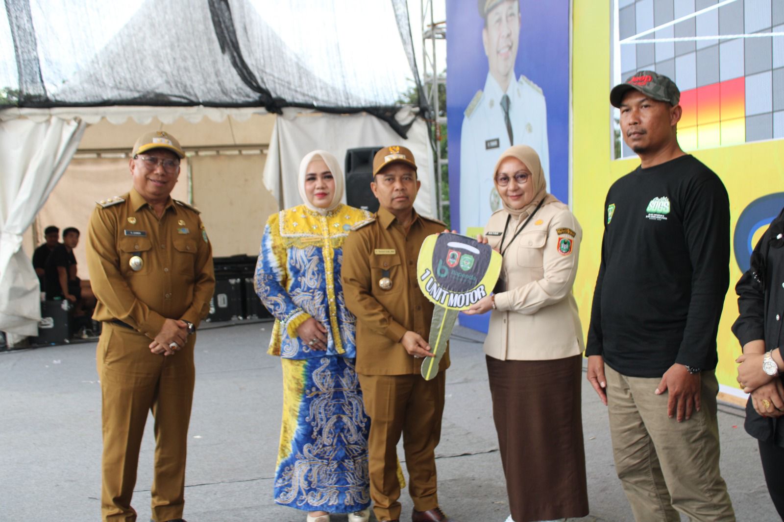 LAMPAUI TARGET OPSEN PAJAK: Kepala UPPD Samsat Rantau Rayna Hendriyani menyerahkan secara simbolis doorprize kepada Bupati Tapin H Yamani untuk mewakili pemenangnya, beberapa waktu lalu.