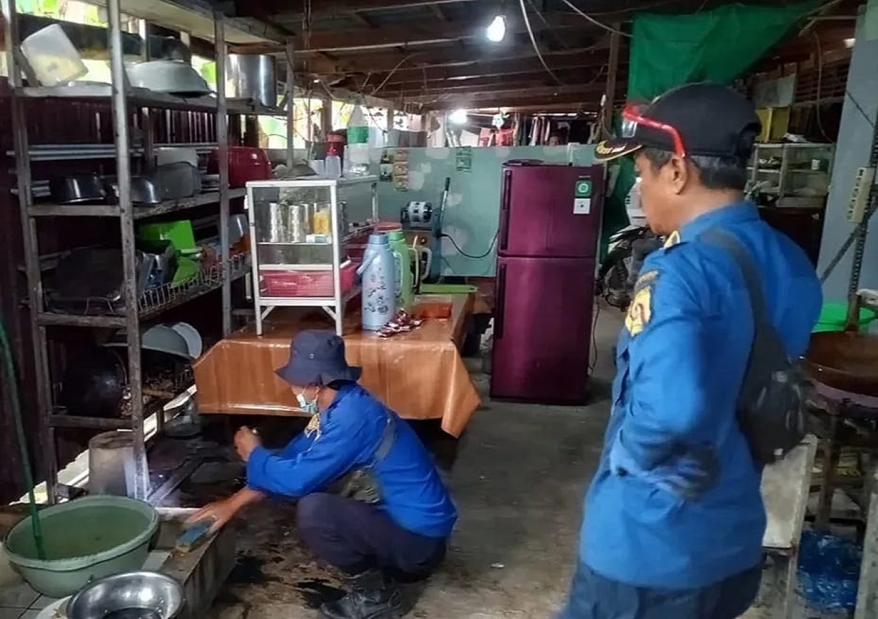 MENGEVAKUASI: Petugas Damkar Banjarbaru mengevakusi seekor ular piton yang ditemukan berada di dapur rumah warga di Syamsudin Noor.