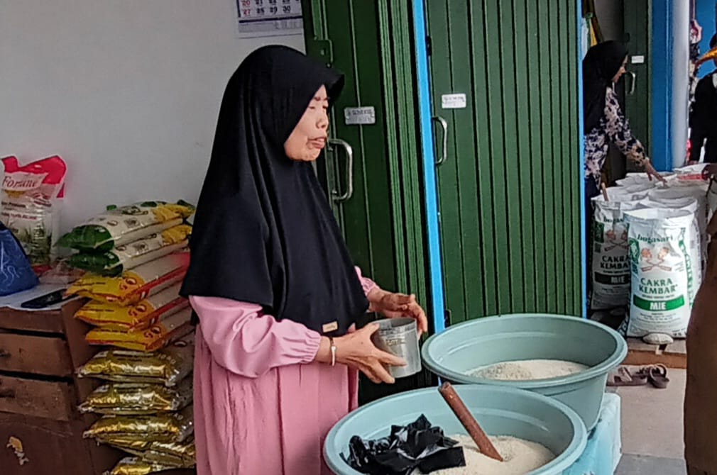 BERAS NAIK : Pedagang beras di Pasar Tanjung saat berjualan di toko miliknya.  (Foto : Ibnu Dwi Wahyudi/Radar Banjarmasin)