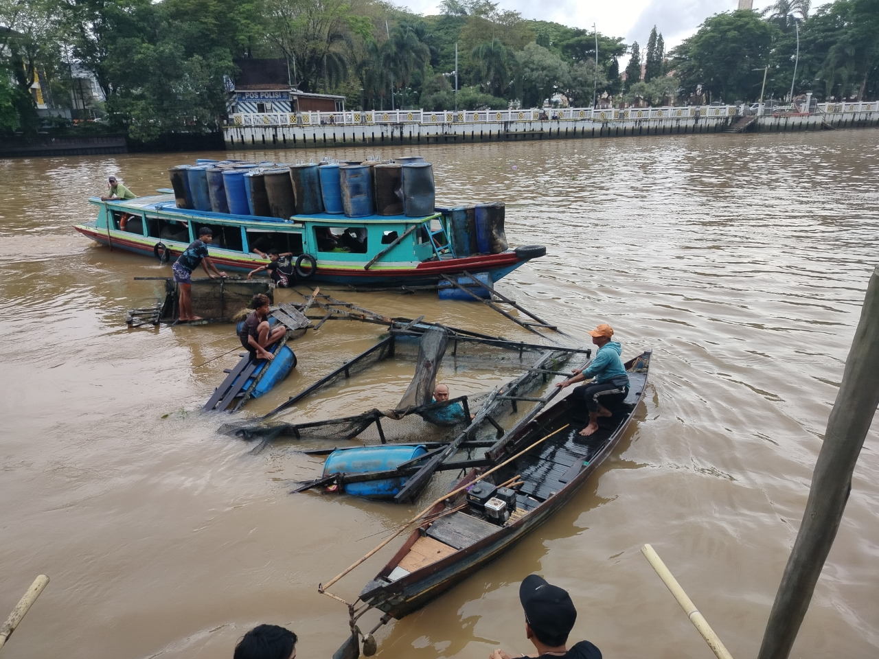 RUGI BANYAK: Dua keramba apung yang masih utuh dan menyisakan ikan di dalamnya sedang dievakuasi