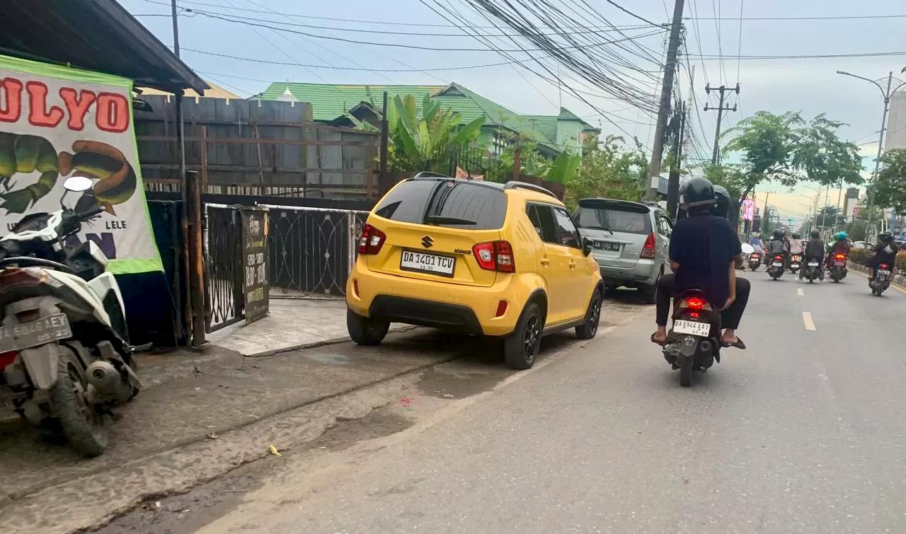 TROTOAR HAK PEJALAN KAKI: Sejumlah kendaraan terpaksa parkir di badan jalan karena banyak pelaku usaha baru membuka usaha tanpa memenuhi kriteria, terutama ketersediaan lahan parkir yang memadai.
