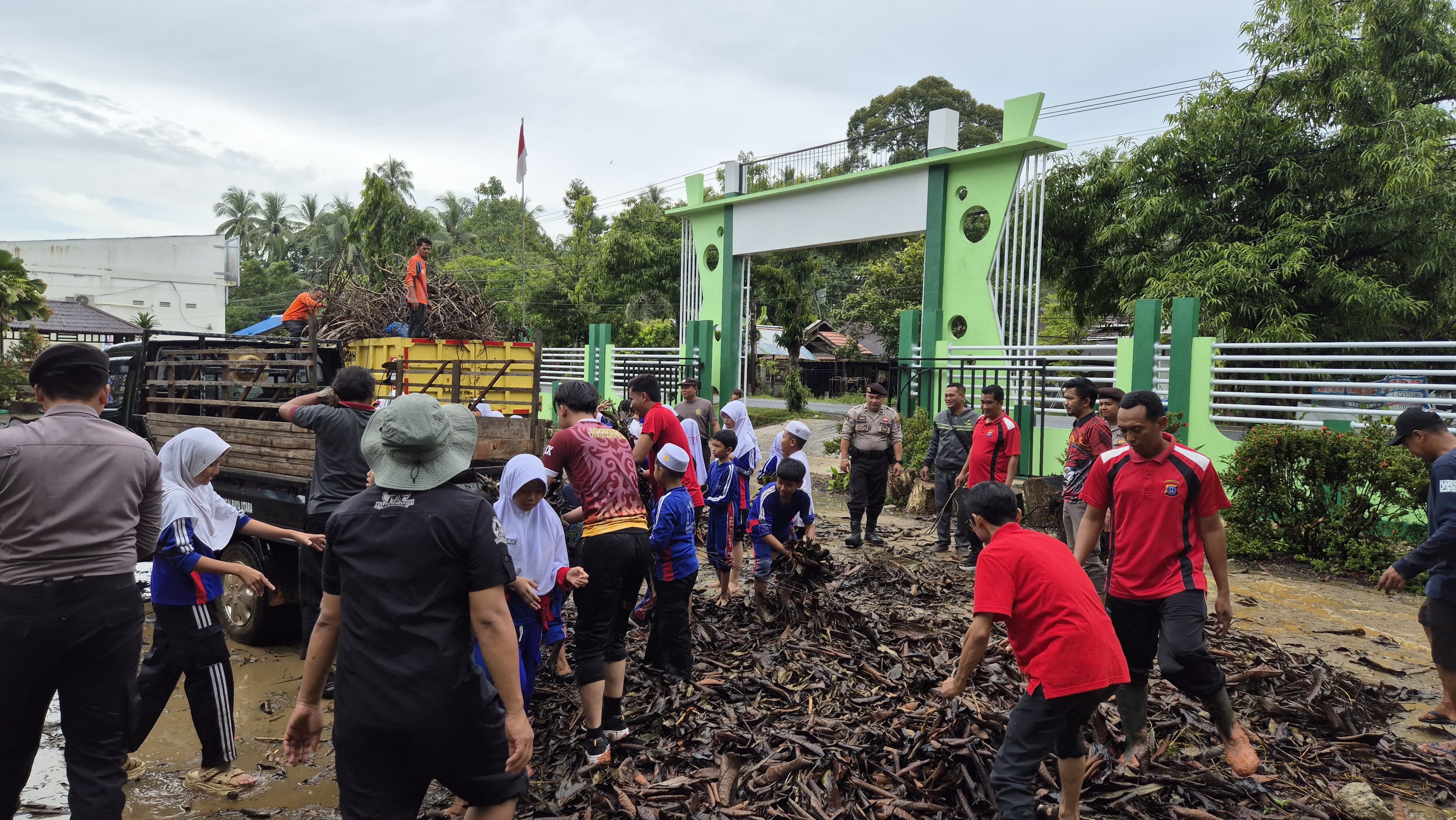MEMBERSIHKAN: POLRES HSS, Polsek Sungai Raya, Dispera KPLH HSS, guru dan siswa SDN Sungai Raya Tengah gotong royong bersihkan sisa pohon tumbang. (POLRES HSS)