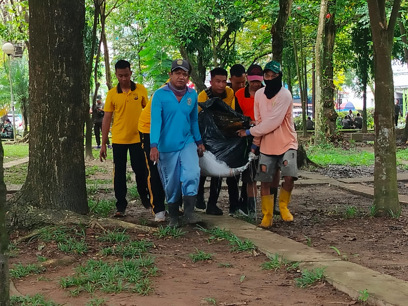 GOTONG ROYONG:Aparat gabungan dari mengangkat sampah yang dikumpulkan dari RTH Kamboja Banjarmasin. //Maulana