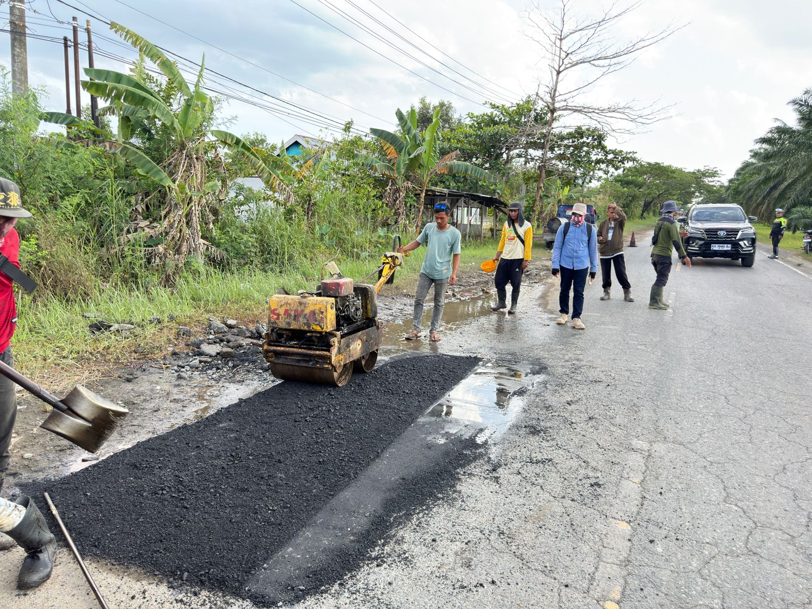 PENGASPALAN: Petugas Satlantas membantu pengaturan lalu lintas saat proses pengaspalan berlangsung di Jalan Hasan Basri, Desa Puntik.//Polres Batola untuk Radar