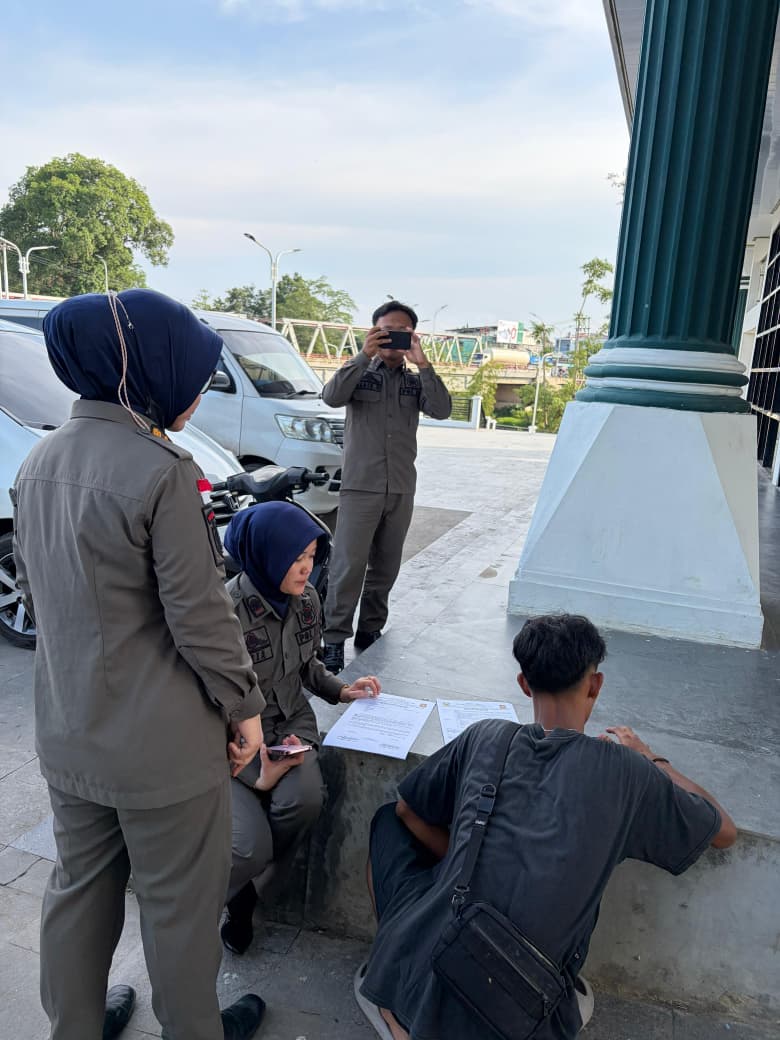 TANDA TANGAN: Seorang pemilik rombong mainan di Taman Siring Paringin menandatangani surat pernyataan untuk tidak lagi menginapkan sarana dagang di area fasilitas publik saat ditertibkan Satpol PP Bal