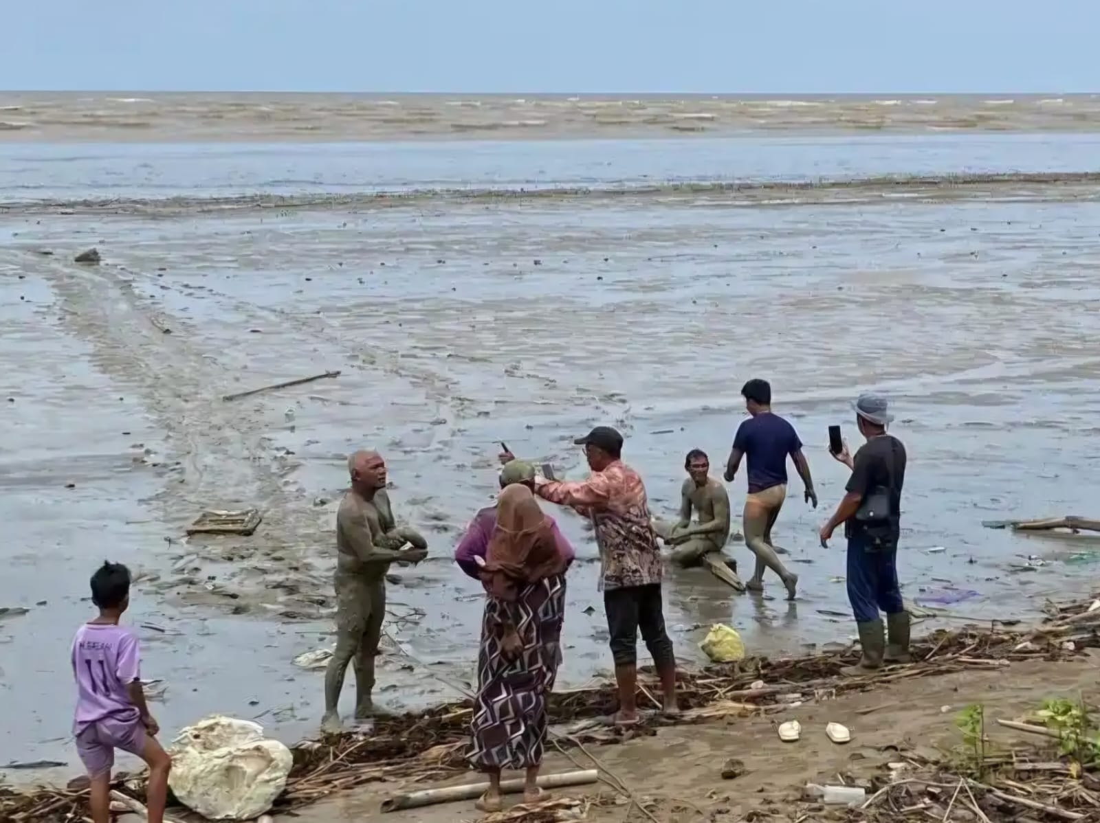 EVAKUASI : Dua nelayan asal Kecamatan Tabunganen, Batola Anang Ali (56) dan Adnan ketika ditolong warga usai kapalnya dihantam ombak. (Foto : Zainuddin untuk Radar Banjarmasin)