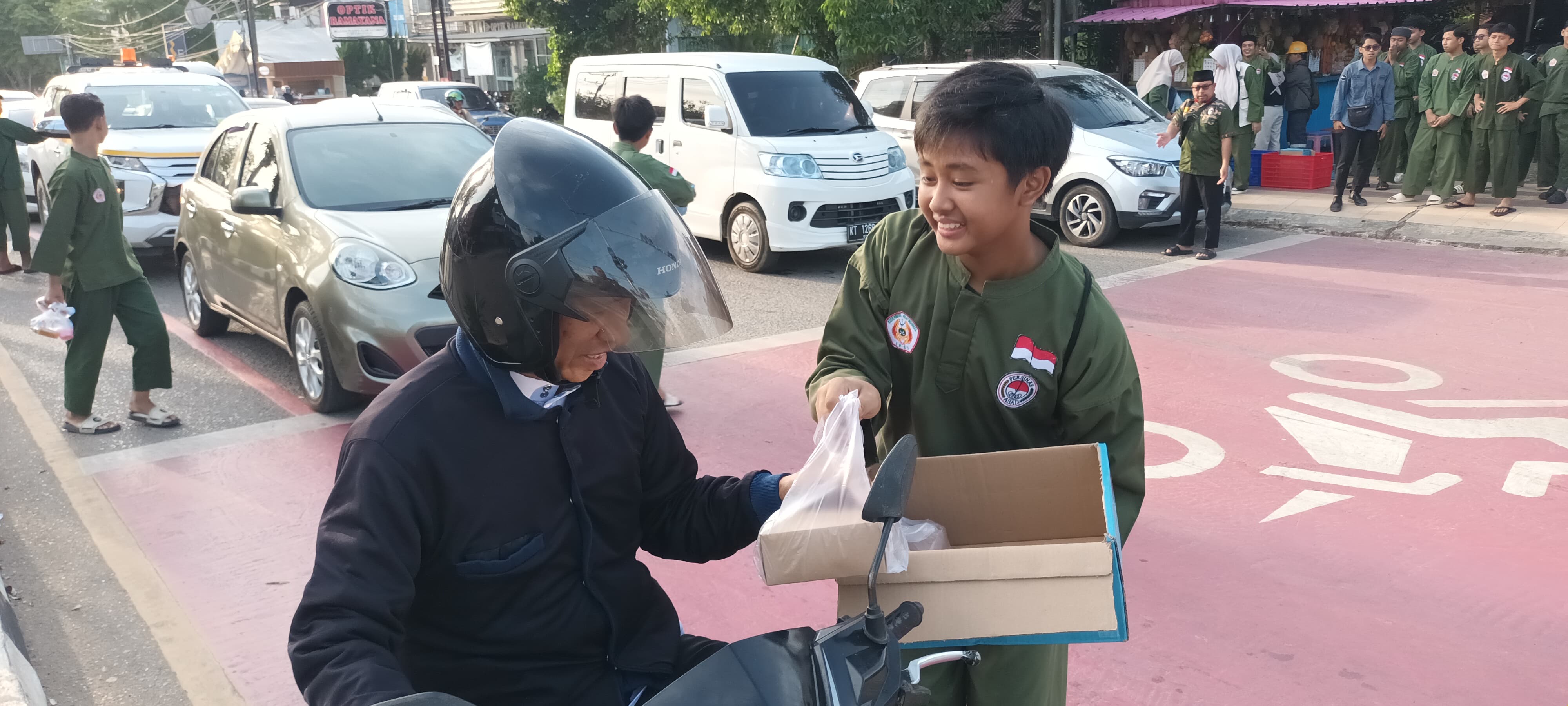 BAGI TAKJIL : Para pesilat Persinas Asad saat memberikan takjil ke pengedara bermotor.  (Foto : Ibnu Dwi Wahyudi/ Radar Banjarmasin)