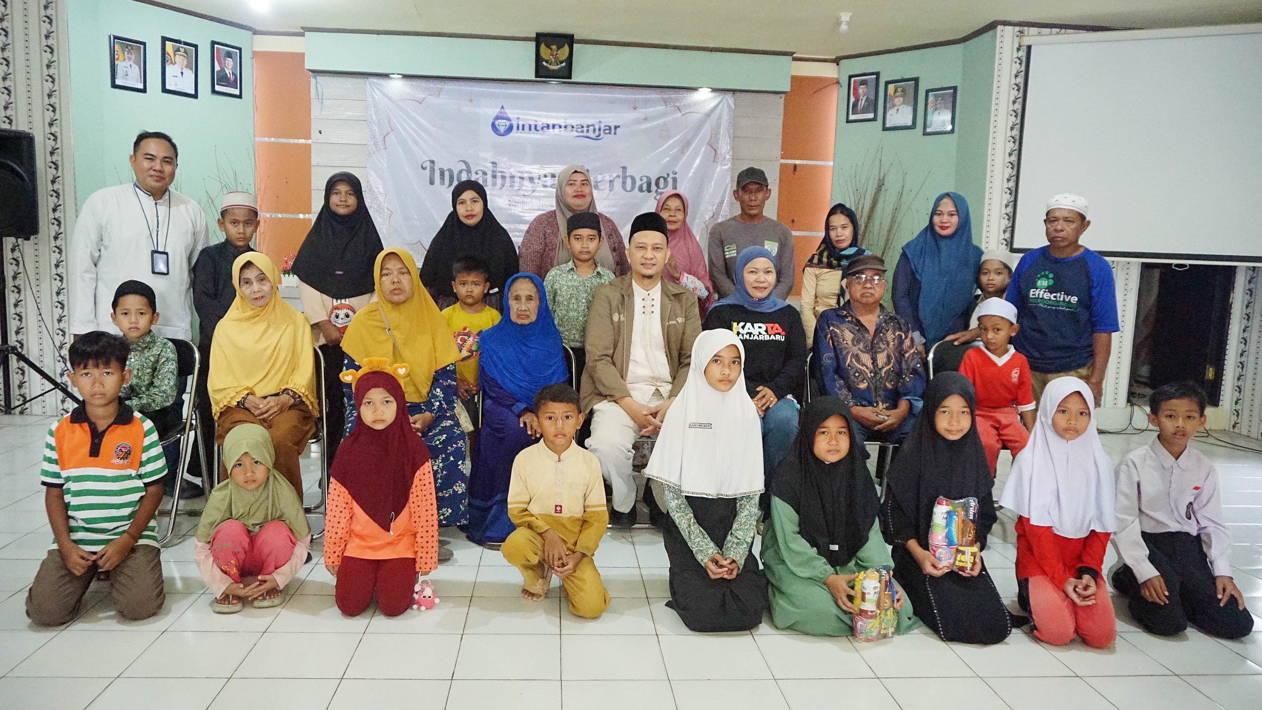FOTO BERSAMA: Perwakilan PT AM Intan Banjar, Radar Banjarmasin, aparat Kelurahan Palam, serta para penerima bantuan berfoto bersama usai menggelar kegiatan Indahnya Berbagi.