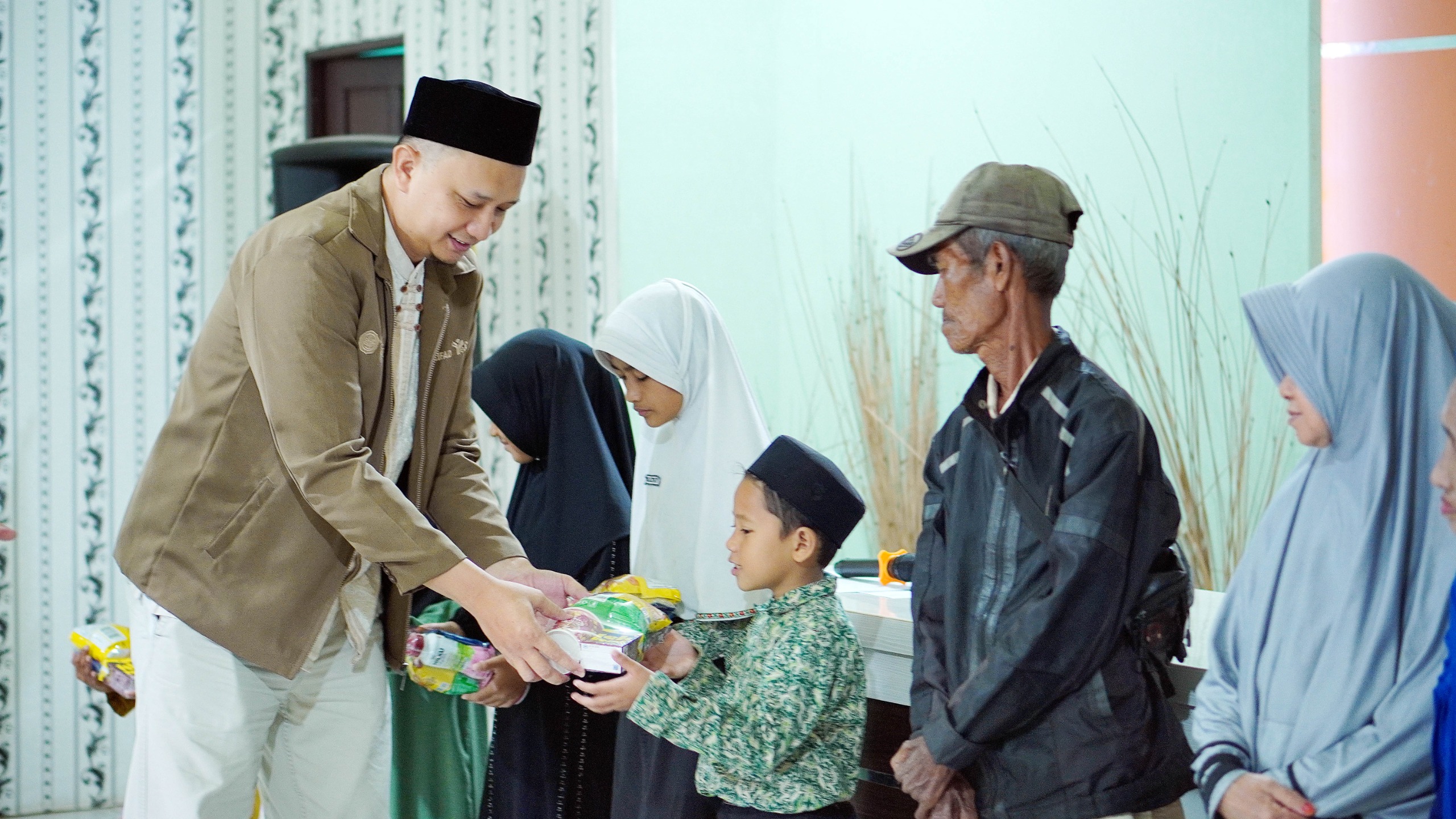 PEDULI: Penyerahan hampers kepada anak yatim dalam kegiatan Indahnya Berbagi.