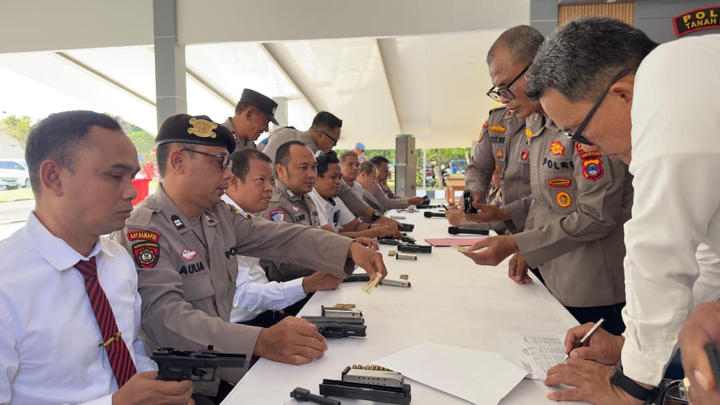 DIPERIKSA: Petugas Polres Tanah Bumbu memeriksa senjata api dinas, amunisi, dan administrasi pemegang senpi milik personel di Pendopo Gajah Mada.