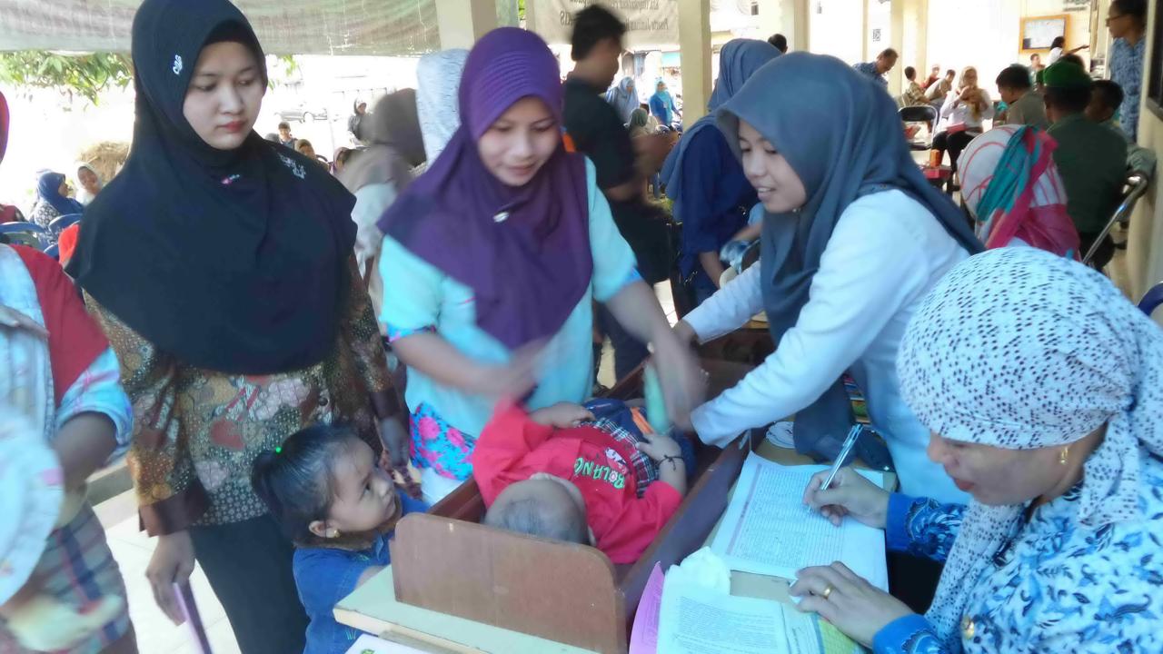 MEMERIKSA: Petugas kesehatan memeriksa kondisi anak saat pelayanan imunisasi di salah satu posyandu di Banjarmasin. 