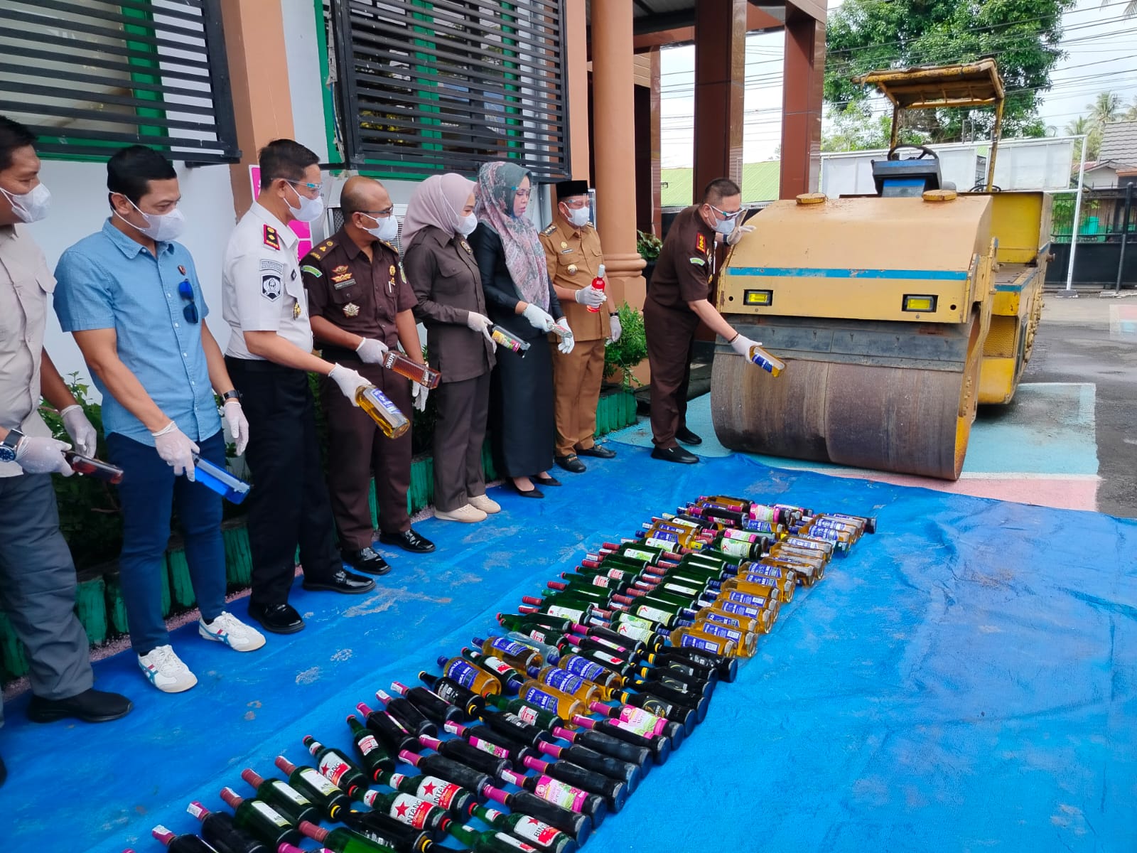 DIMUSNAHKAN: Kepala Kejari Batola Andrianto Budi Santoso memecahkan satu botol miras barang bukti perkara pidana yang telah berkekuatan hukum tetap di halaman Kantor Kejari Barito Kuala.