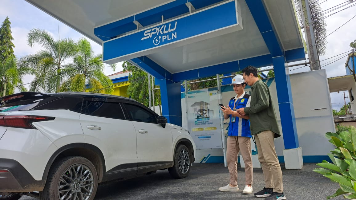 ASISTENSI:Petugas PLN UID Kalselteng membantu pemilik mobil listrik mengisi ulang daya mobil listrik di SPKLU milik PLN.   