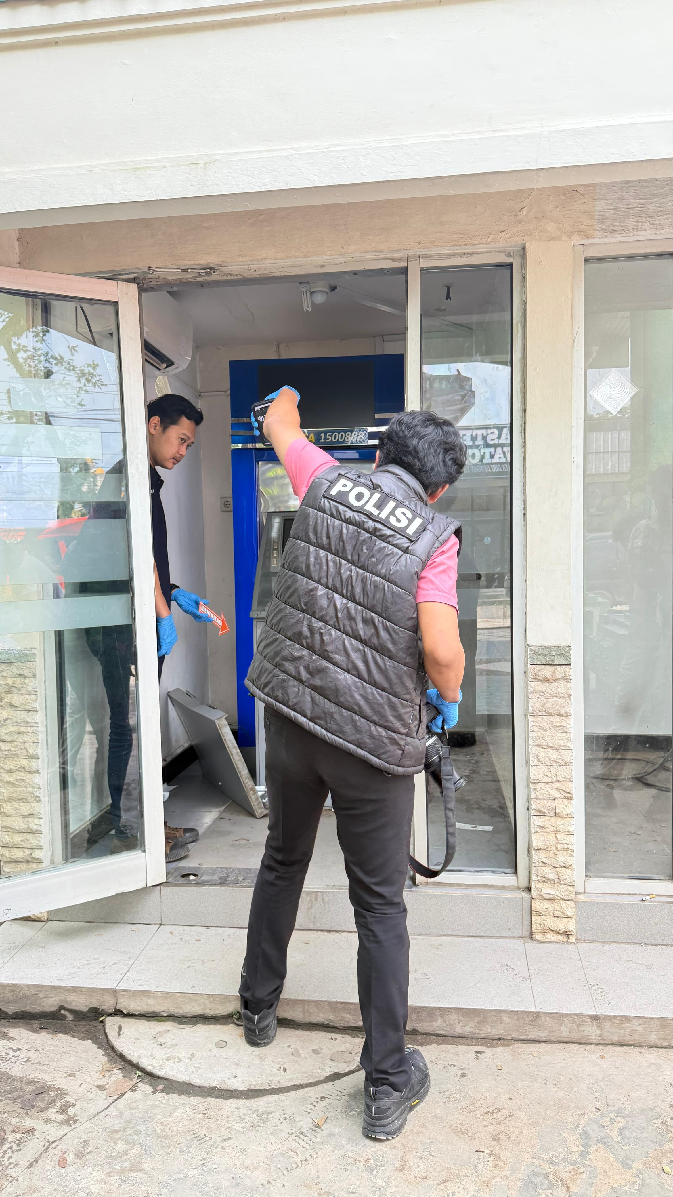 MEMASANG: Petugas kepolisian memasang garis polisi di mesin ATM BCA di Jalan Ahmad Yani Km 39, Martapura, yang menjadi lokasi dugaan percobaan pembobolan, Kamis (12/3/2026). (POLRES BANJAR)