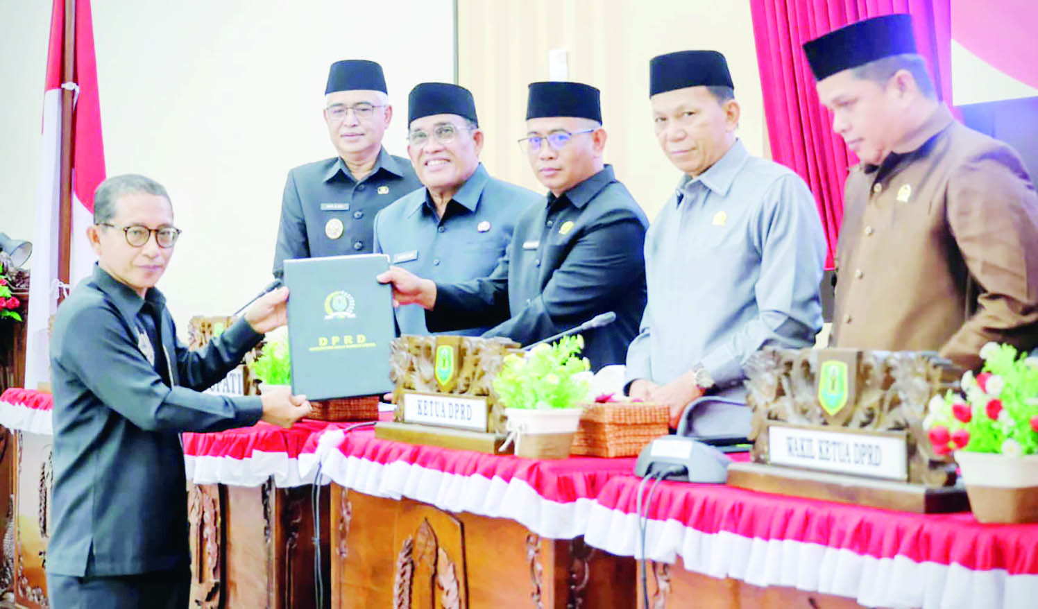 SERAHKAN: Juru bicara FB Junaidi, menyerahkan draf pandangan fraksinya pimpinan dewan, disaksikan Bupati HSU H Sahrujani dan Wabup Hero Setiawan, di ruang Paripurna Dewan HSU.
