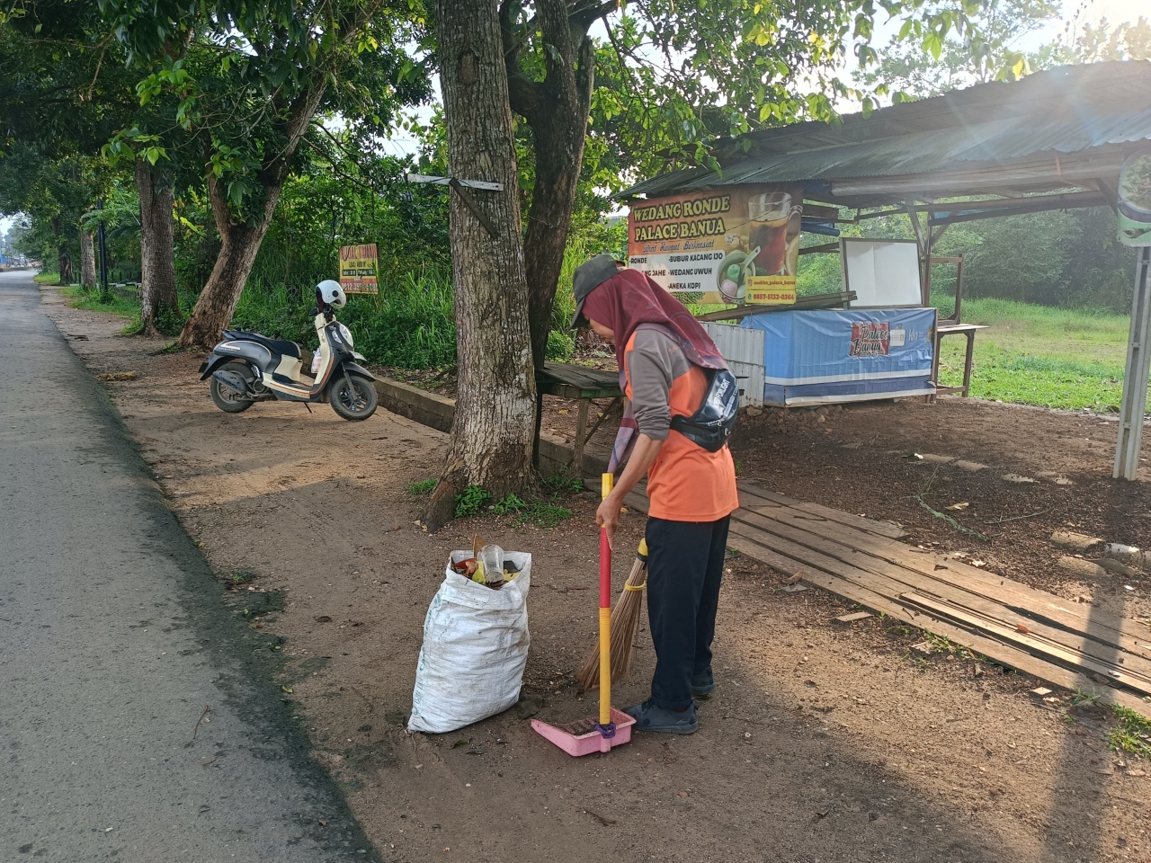 MENYAPU: Parida saat menyapu sampah di Jalan Guntung Manggis, Kelurahan Guntung Manggis, Kecamatan Landasan Ulin. 