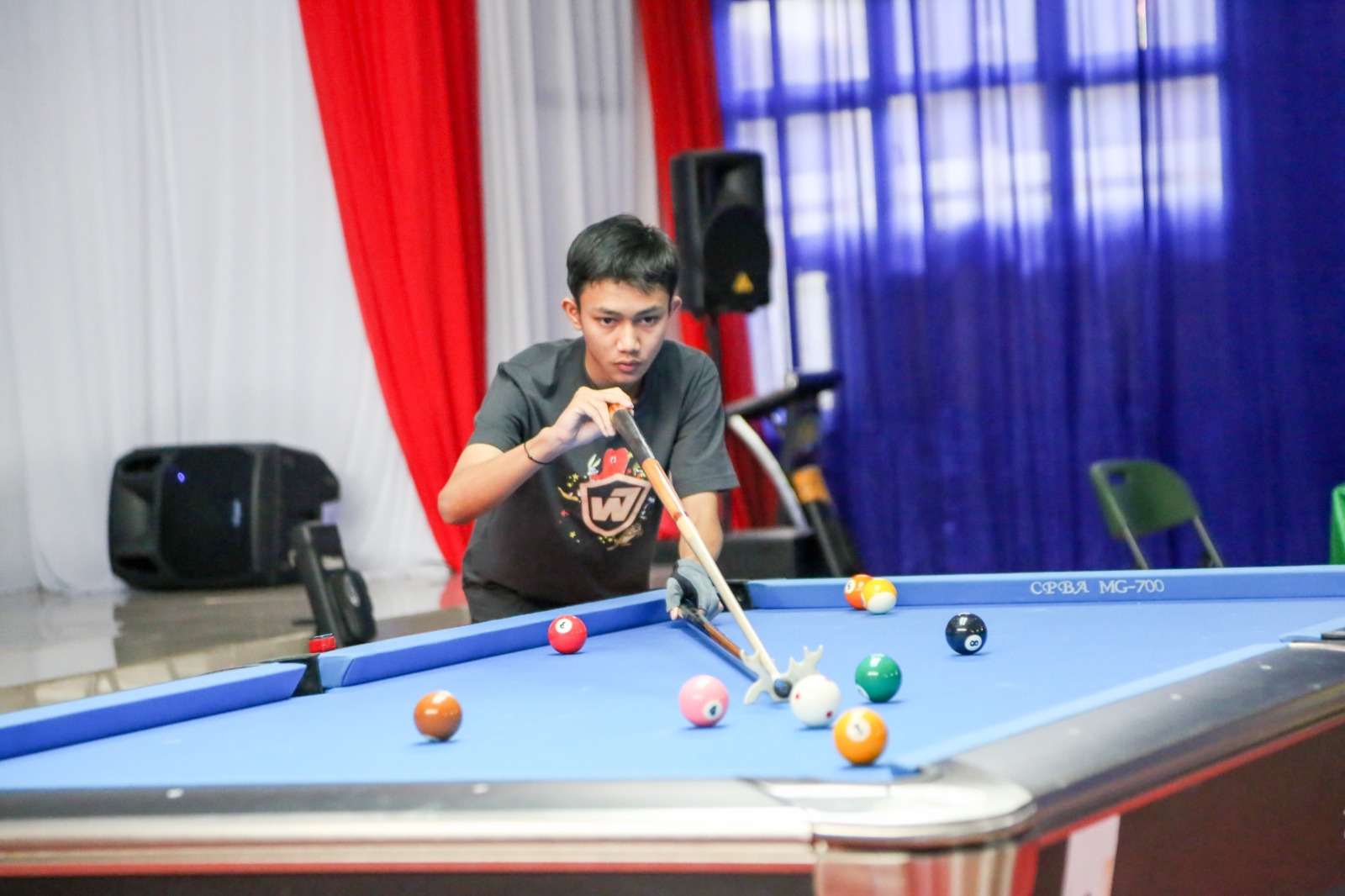 BIDIK BOLA: Seorang pebiliar muda berkonsentrasi penuh saat melancarkan tembakan dalam sebuah pertandingan. Ini mencerminkan potensi besar atlet mahasiswa yang kini memiliki panggung kompetisi lebih