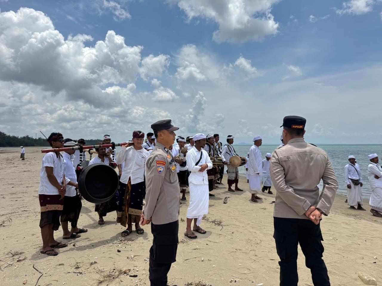 MELASTI: Personel kepolisian mengamankan prosesi Melasti umat Hindu di Pantai Madani, Desa Sungai Loban, Tanah Bumbu, Senin (16/3). Upacara ini digelar menjelang Hari Raya Nyepi Tahun Baru Saka 1948.