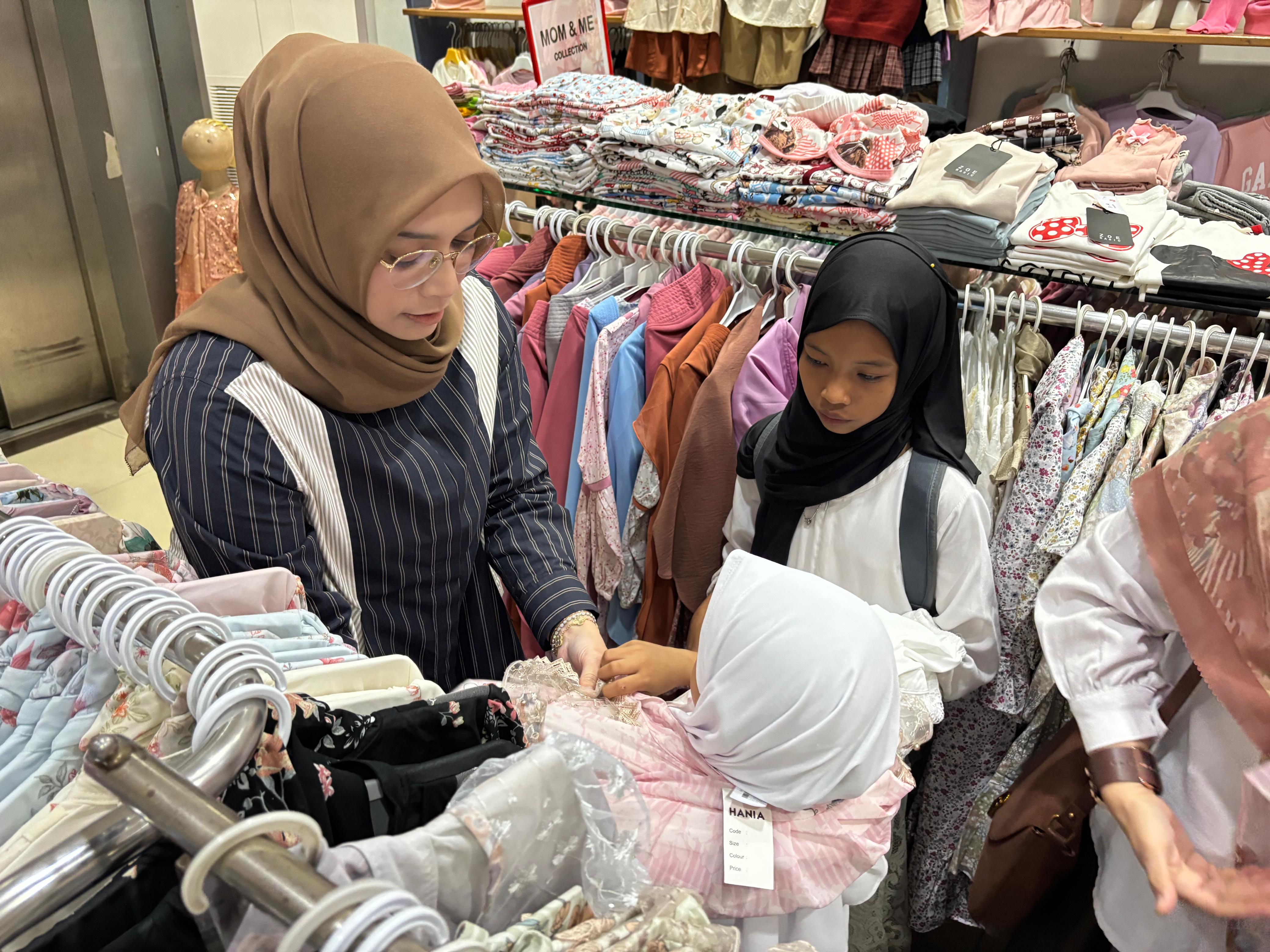 Ketua IKA Unair Kalsel, drg Ellyana Trisya Hasnuryadi membantu anak-anak memilih pakaian baru untuk lebaran.
