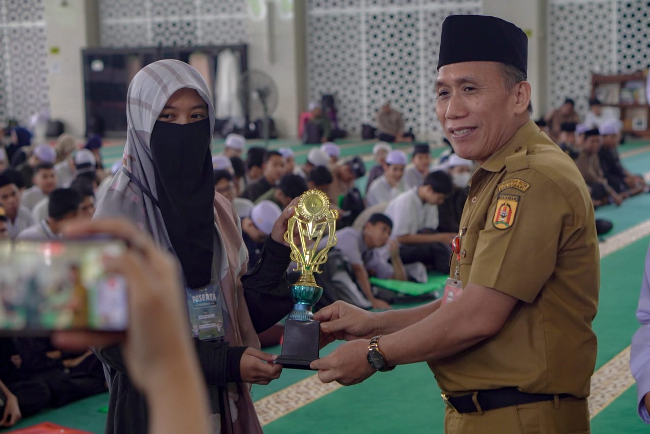 Staf Ahli Wali Kota Banjarbaru Bidang Hukum dan Politik, Marhain Rahman menyerahkan trofi ke salah satu peserta Pesantren Ramadhan 1447 H di Masjid Agung Al-Munawwarah Banjarbaru, Senin (2/3/2026).