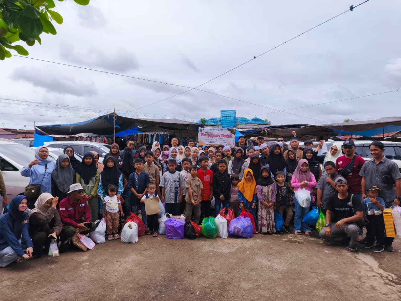 KEBERSAMAAN: Karyawan PAMA ARIA berfoto bersama anak-anak yatim dari Satui dan Kintap saat kegiatan Belanja Ramadan di Pasar Sungai Danau.