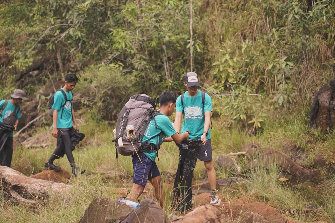 SAPU BERSIH: Anggota Pokdarwis Kahung Raya membersihkan sampah sisa logistik pendaki di kawasan Gunung Kahung, Kabupaten Banjar.