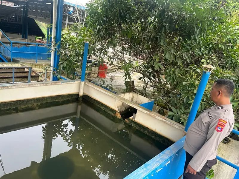 MAKAN KORBAN:Petugas kepolisian saat melakukan olah tempat kejadian perkara di area kolam penampungan air milik PDAM di Desa Badalungga, Kecamatan Awayan. 
