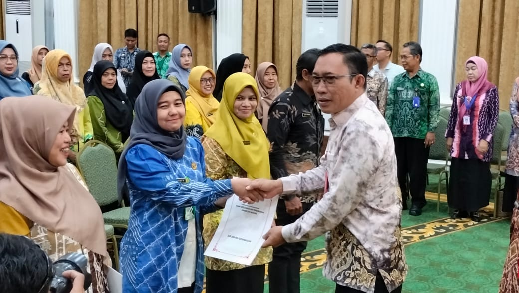 MENYERAHKAN: Sekdakot Banjarbaru Sirajoni saat menyerahkan SK kenaikan pangkat pada ASN Pemko Banjarbaru. (SHEILLA /RADAR BANJARMASIN)
